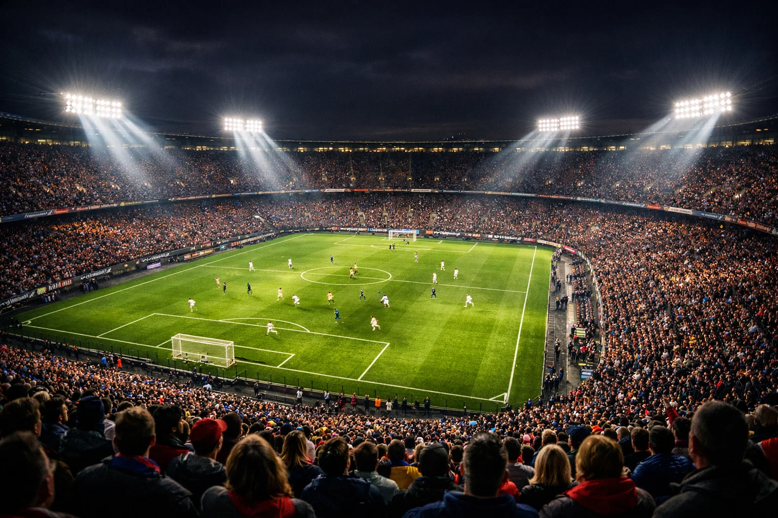 Vista nocturna de um estádio de futebol iluminado durante um jogo com adeptos nas bancadas
